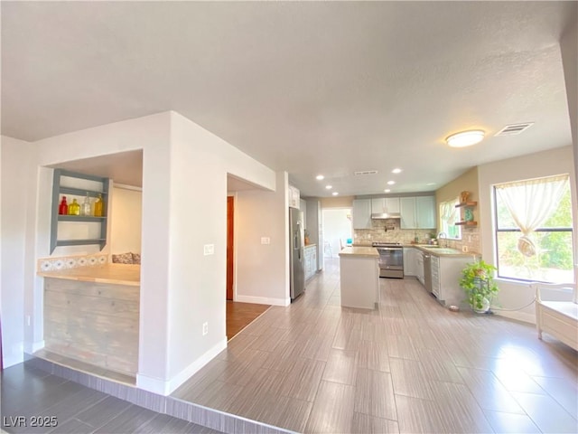 5381 Waving Sage Dr, Las Vegas, NV 89149 - kitchen featuring range, stainless steel fridge with ice dispenser, baseboards, backsplash, and a kitchen island