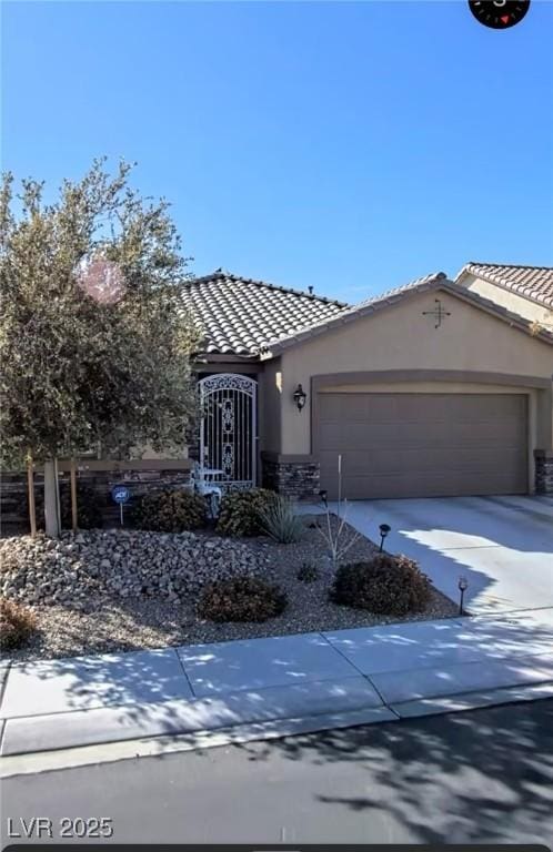 view of front of home with a tiled roof, stucco siding, an attached garage, and driveway