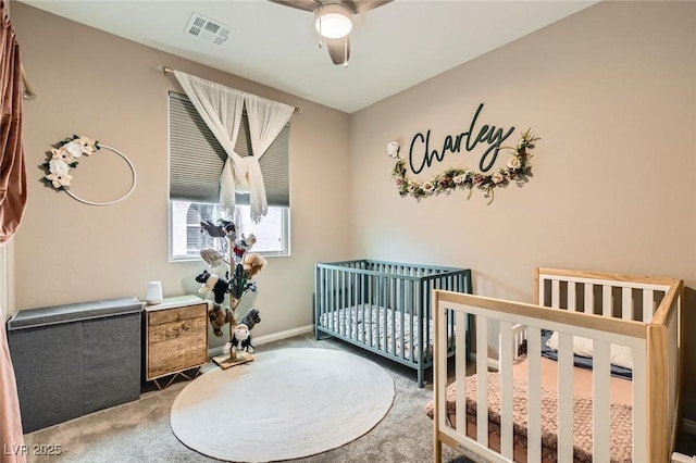 bedroom with carpet, baseboards, ceiling fan, and a crib