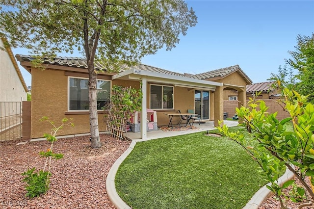 rear view of property featuring stucco siding, a tiled roof, and a patio area