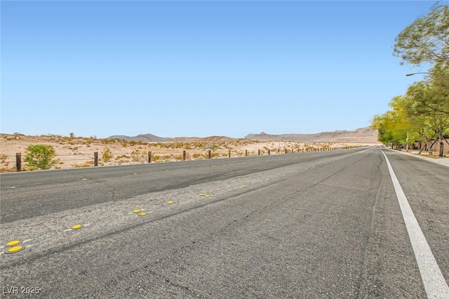 7497 Alamo Ranch Ave, Las Vegas, NV 89179 - view of asphalt road with a mountain view and street lighting