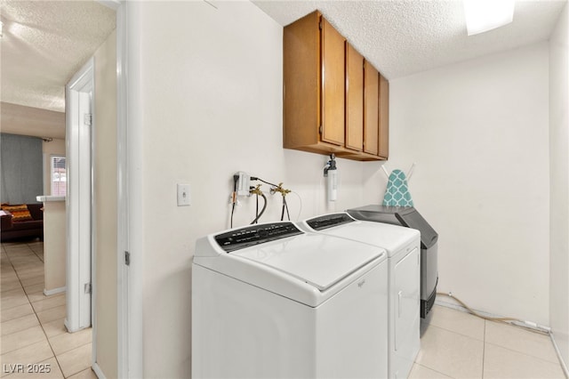 5361 Cabrito Dr, Las Vegas, NV 89103 - laundry area featuring a textured ceiling, cabinet space, independent washer and dryer, and light tile patterned flooring