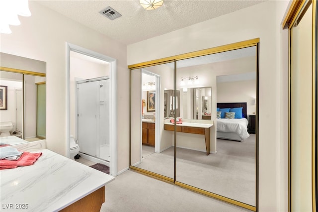 5361 Cabrito Dr, Las Vegas, NV 89103 - bedroom featuring visible vents, a textured ceiling, ensuite bathroom, and light carpet