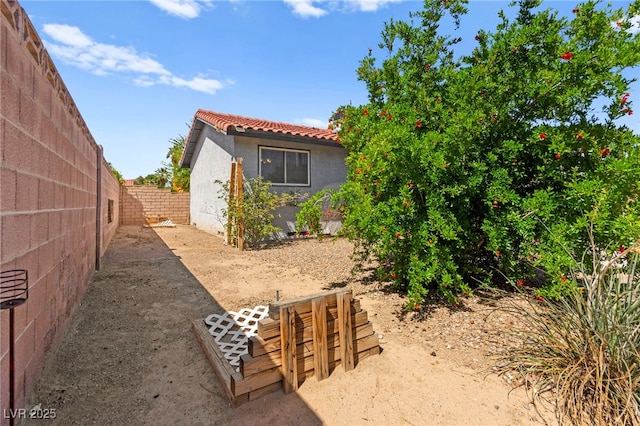 5361 Cabrito Dr, Las Vegas, NV 89103 - view of side of home featuring a fenced backyard, stucco siding, and a tiled roof