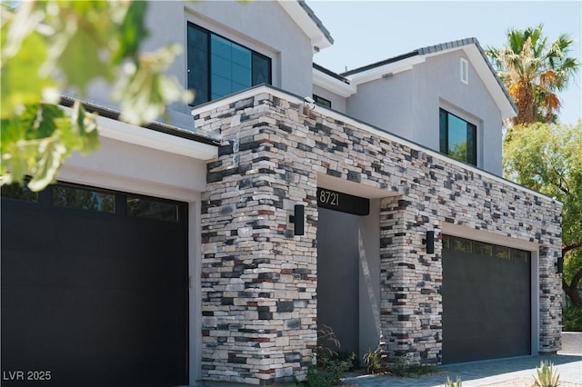8721 Robinson Ridge Dr, Las Vegas, NV 89117 - view of side of property featuring a garage, stucco siding, stone siding, and driveway