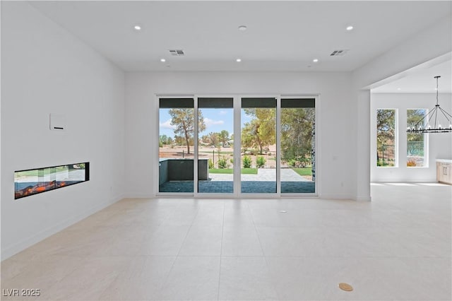 8721 Robinson Ridge Dr, Las Vegas, NV 89117 - spare room featuring recessed lighting, a chandelier, a glass covered fireplace, healthy amount of natural light, and light tile patterned flooring