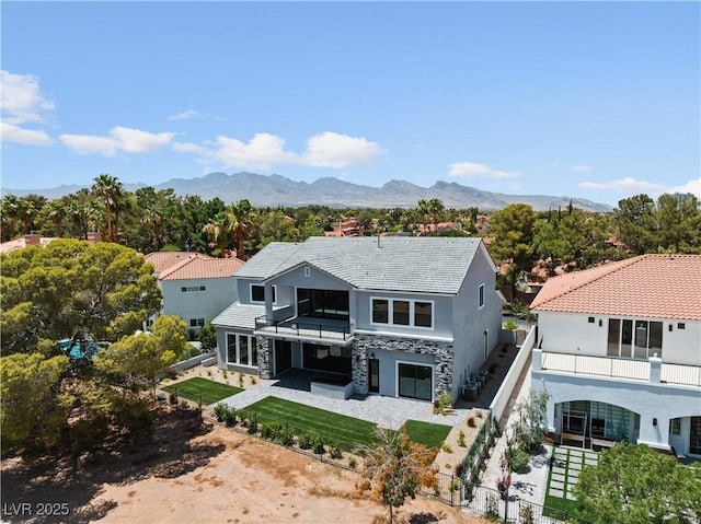 8721 Robinson Ridge Dr, Las Vegas, NV 89117 - view of front of home with a balcony, stone siding, a fenced backyard, stucco siding, and a patio