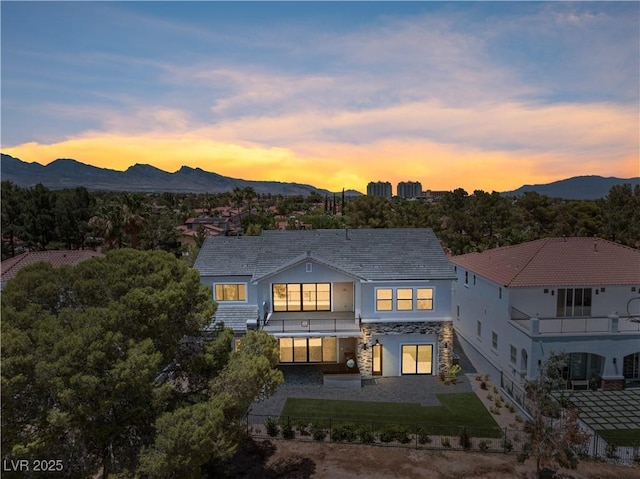 8721 Robinson Ridge Dr, Las Vegas, NV 89117 - back of property at dusk featuring stone siding, stucco siding, and a mountain view