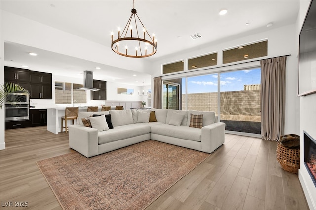 9815 Evergreen Pine St, Las Vegas, NV 89166 - living area featuring recessed lighting, visible vents, an inviting chandelier, and light wood-style floors