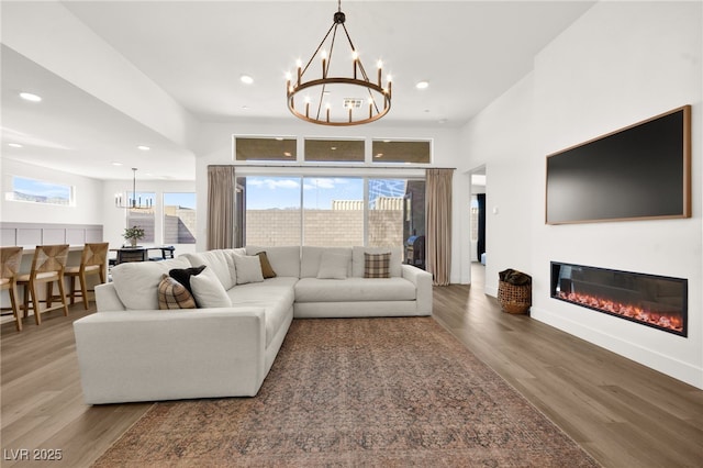 9815 Evergreen Pine St, Las Vegas, NV 89166 - living area featuring recessed lighting, a glass covered fireplace, wood finished floors, and a notable chandelier