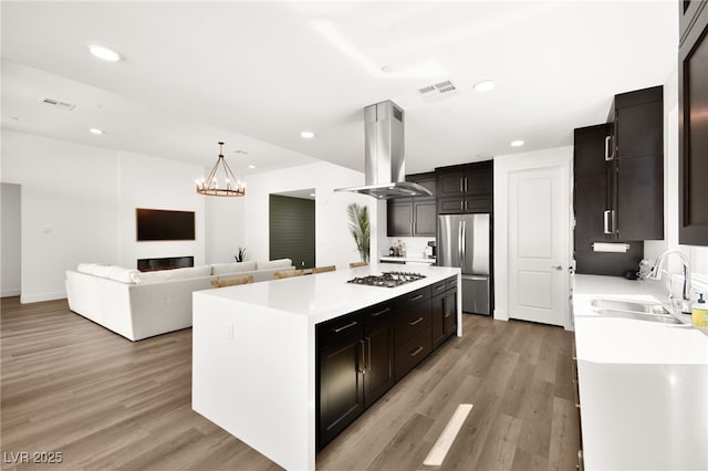 9815 Evergreen Pine St, Las Vegas, NV 89166 - kitchen with a kitchen island, light wood-type flooring, island exhaust hood, a sink, and stainless steel appliances