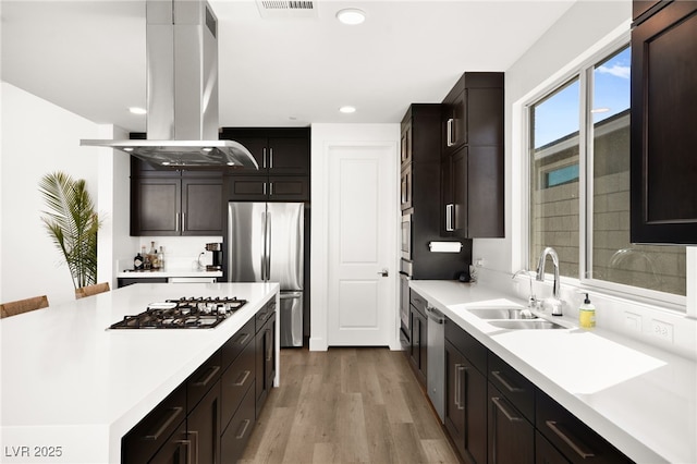 9815 Evergreen Pine St, Las Vegas, NV 89166 - kitchen featuring light wood-style floors, island range hood, light countertops, a sink, and appliances with stainless steel finishes
