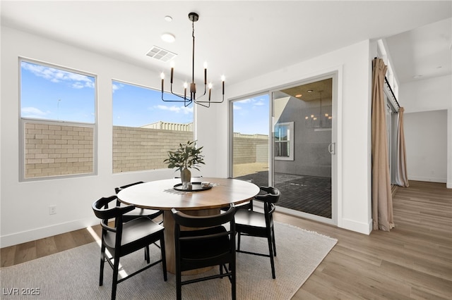 9815 Evergreen Pine St, Las Vegas, NV 89166 - dining room with baseboards, an inviting chandelier, wood finished floors, and visible vents