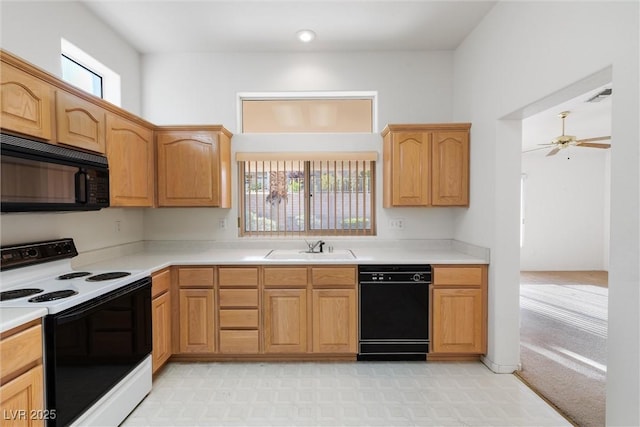 kitchen with a sink, light countertops, light floors, visible vents, and black appliances