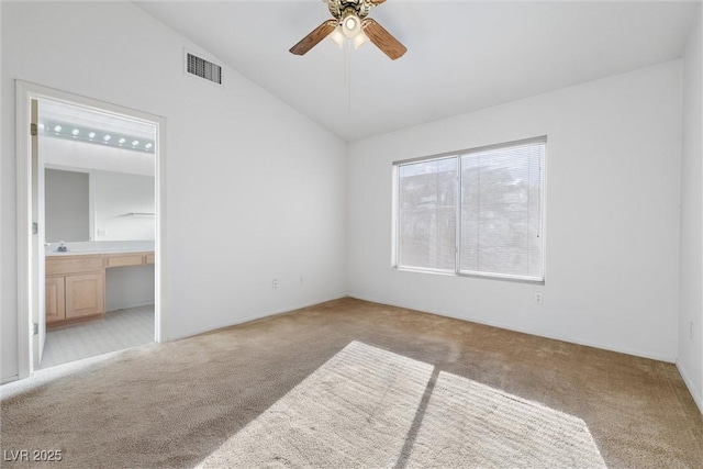 unfurnished bedroom with visible vents, carpet flooring, ensuite bath, and lofted ceiling