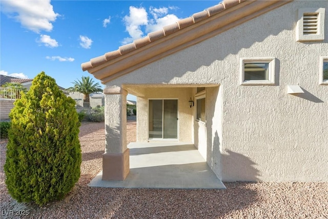 rear view of house with a patio area and stucco siding