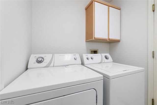 laundry room featuring separate washer and dryer and cabinet space
