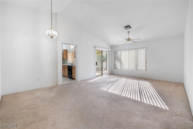 unfurnished living room with light colored carpet, ceiling fan with notable chandelier, visible vents, and high vaulted ceiling