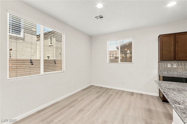 unfurnished dining area with recessed lighting, baseboards, light wood-type flooring, and visible vents