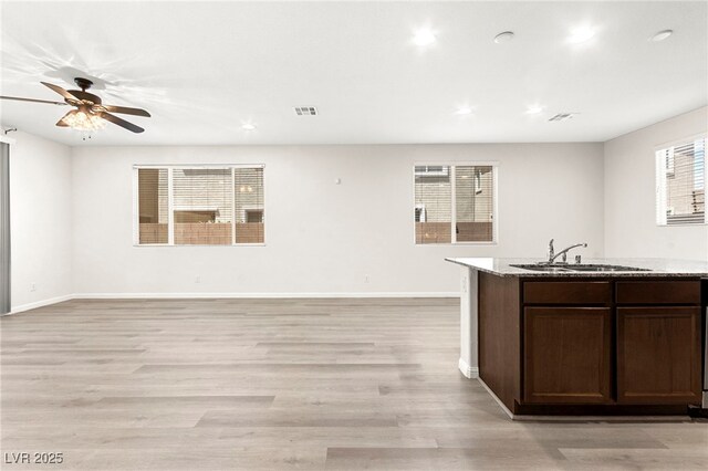 kitchen with visible vents, a sink, ceiling fan, and open floor plan