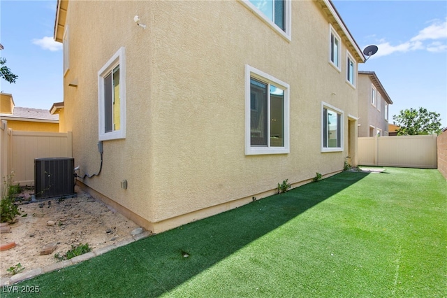 view of home's exterior featuring stucco siding, a fenced backyard, and central AC