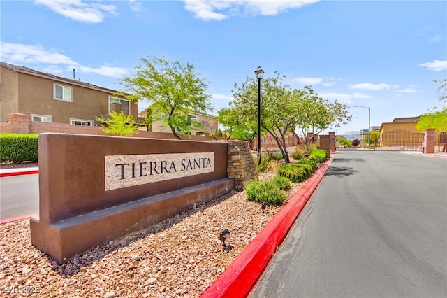 community sign with fence and a residential view