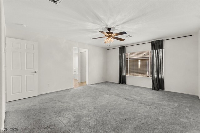 spare room featuring carpet floors, a ceiling fan, baseboards, and visible vents