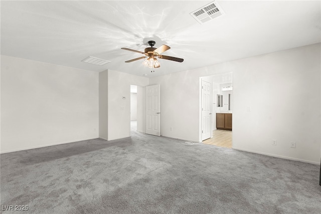 interior space featuring light colored carpet, baseboards, visible vents, and ceiling fan