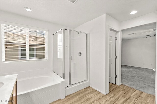 full bathroom featuring a garden tub, vanity, wood finished floors, and a shower stall