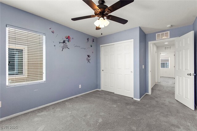 unfurnished bedroom featuring a ceiling fan, visible vents, baseboards, a closet, and carpet