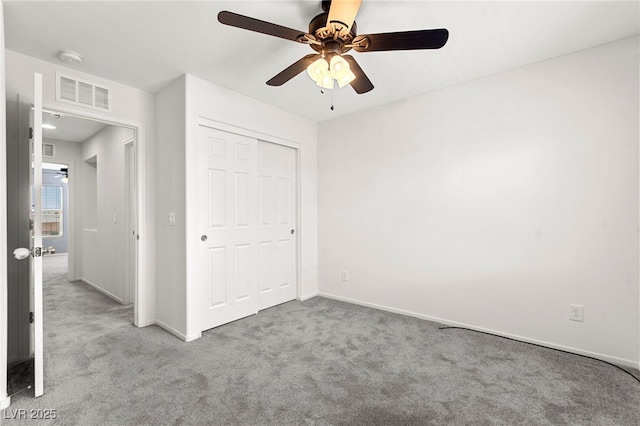 unfurnished bedroom featuring carpet flooring, a ceiling fan, baseboards, visible vents, and a closet