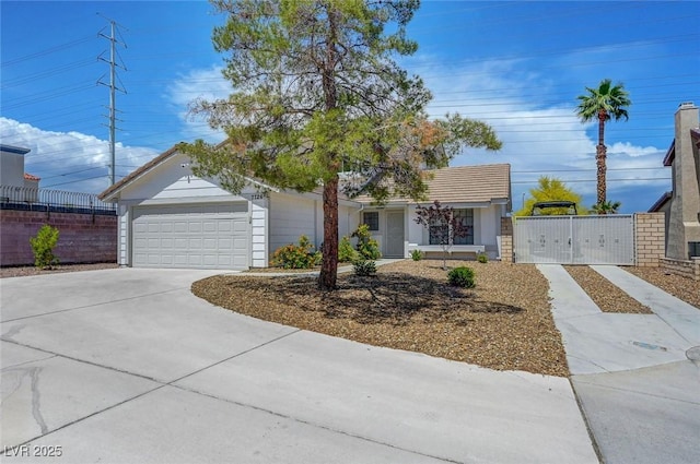 ranch-style house with a gate, fence, an attached garage, and driveway