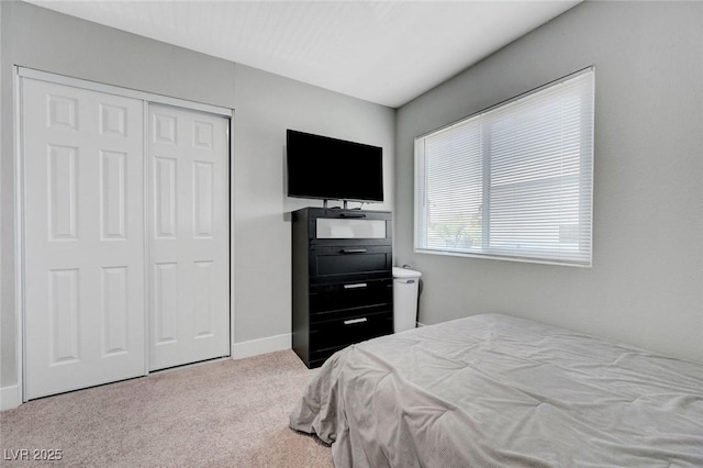 carpeted bedroom with baseboards and a closet