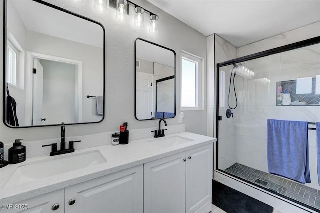 full bathroom featuring a sink, double vanity, and a shower stall