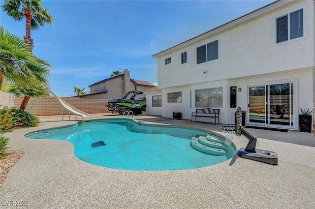 view of pool featuring a fenced backyard, a patio, a fenced in pool, and a water slide