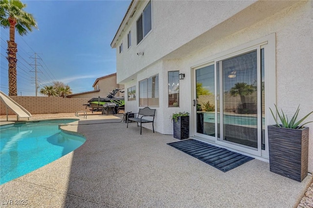 view of pool with a patio, a fenced in pool, a water slide, and a fenced backyard
