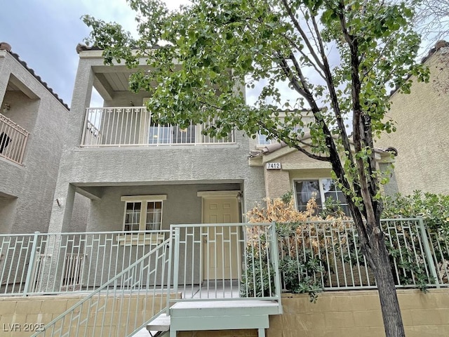 view of front facade featuring a balcony and stucco siding