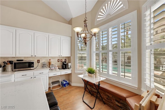 2909 Sterling Cove Dr, Las Vegas, NV 89128 - dining room featuring light wood-style floors, baseboards, a notable chandelier, and lofted ceiling