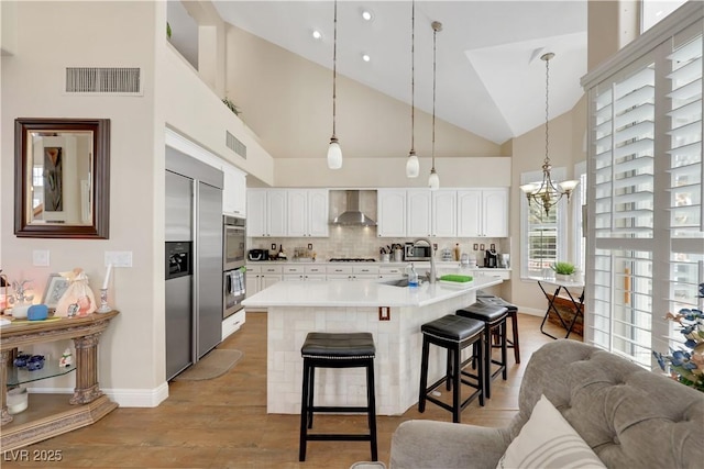 2909 Sterling Cove Dr, Las Vegas, NV 89128 - kitchen with a kitchen breakfast bar, visible vents, stainless steel appliances, and wall chimney exhaust hood