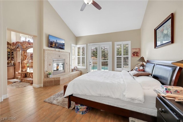 2909 Sterling Cove Dr, Las Vegas, NV 89128 - bedroom with wood finished floors, high vaulted ceiling, multiple windows, and a fireplace
