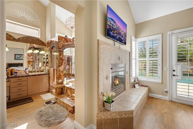 2909 Sterling Cove Dr, Las Vegas, NV 89128 - interior space featuring vanity, a garden tub, a fireplace, hardwood / wood-style floors, and high vaulted ceiling