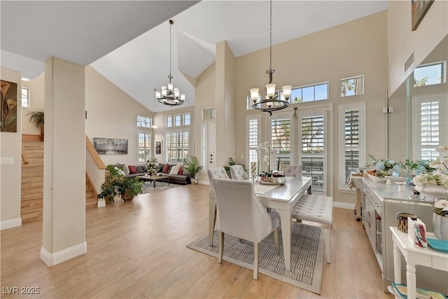 2909 Sterling Cove Dr, Las Vegas, NV 89128 - dining area with an inviting chandelier, light wood-type flooring, high vaulted ceiling, and stairway
