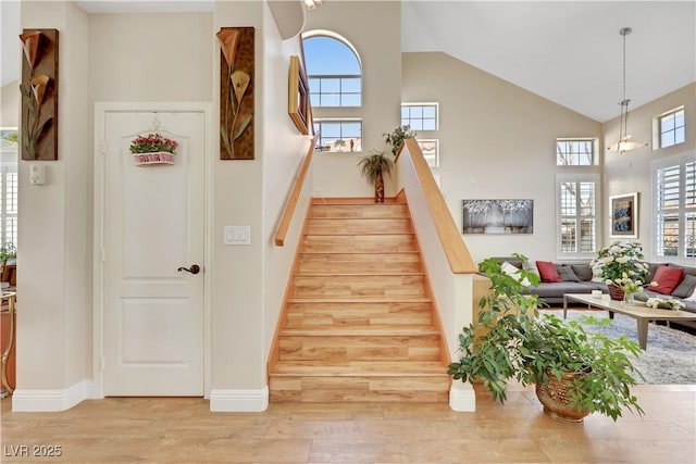 2909 Sterling Cove Dr, Las Vegas, NV 89128 - stairs with high vaulted ceiling, baseboards, and wood finished floors