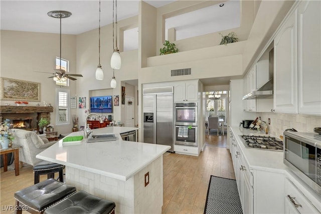 2909 Sterling Cove Dr, Las Vegas, NV 89128 - kitchen with a ceiling fan, visible vents, a sink, a breakfast bar, and stainless steel appliances