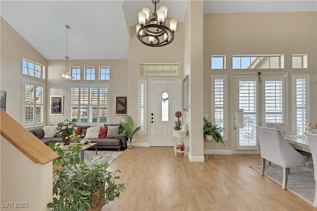 2909 Sterling Cove Dr, Las Vegas, NV 89128 - entryway featuring an inviting chandelier, high vaulted ceiling, baseboards, and light wood-type flooring