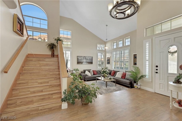 2909 Sterling Cove Dr, Las Vegas, NV 89128 - foyer entrance featuring light wood-type flooring, healthy amount of natural light, stairway, high vaulted ceiling, and a chandelier