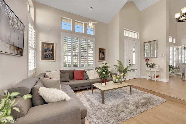 2909 Sterling Cove Dr, Las Vegas, NV 89128 - living area featuring an inviting chandelier, wood finished floors, a healthy amount of sunlight, and high vaulted ceiling