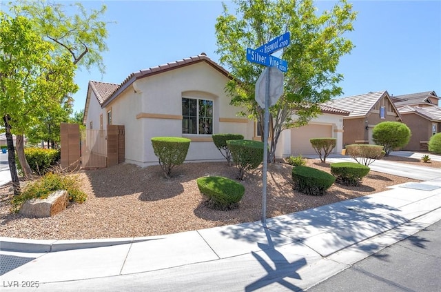 mediterranean / spanish home featuring a tiled roof, an attached garage, and stucco siding
