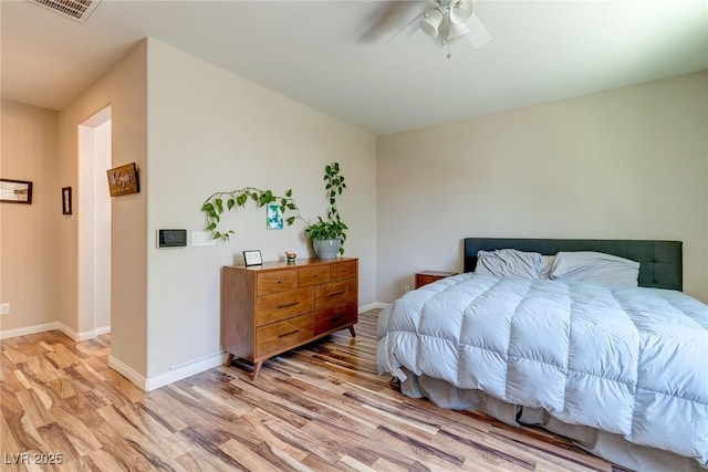 bedroom with visible vents, light wood-style flooring, ceiling fan, and baseboards