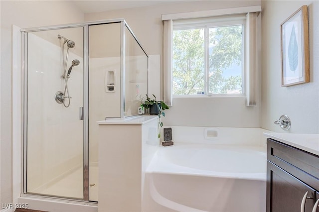 bathroom featuring a garden tub, a stall shower, and vanity